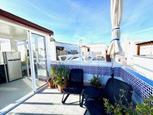 a balcony with two chairs and a boat on it at Zenit Olhao baixa one bedroom house sea side view in Olhão +31 photos