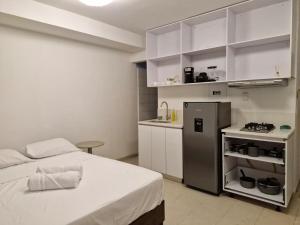 a small kitchen with a bed and a refrigerator at Loft 204 - H54 WAIWA HOST in Bucaramanga
