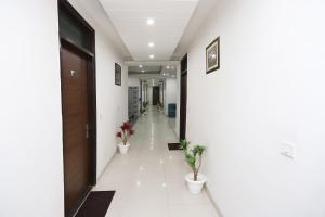 a hallway with two potted plants in a building at Capital O Levanti Near Aravali Biodiversity Park in Gurgaon