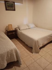 a bedroom with two beds and a side table at El Portal in Posadas