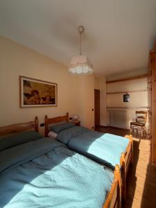 two twin beds in a bedroom with a chandelier at Ciasa Caligher in Venas