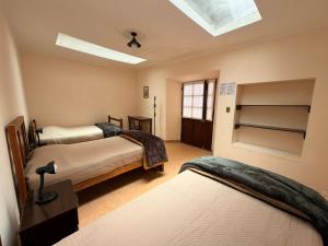 a bedroom with two beds and a skylight at Casa Grau in Sucre