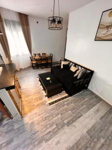 a living room with a black couch and a table at Dar el bahdja in Sidi MʼHamed