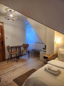 a bedroom with a bed and a table and chairs at Uroczysko pod Babią Górą in Zawoja