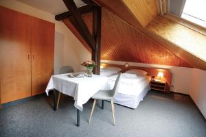 a bedroom with a bed and a table and chairs at Klindworths Gasthof in Sauensiek
