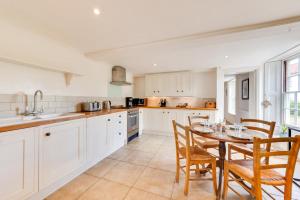 a kitchen with white cabinets and a table and chairs at 4 Bed in Wangford oc-2tov in Wangford