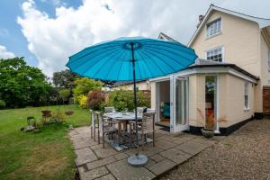 a patio with a table with a blue umbrella at 4 Bed in Wangford oc-2tov in Wangford