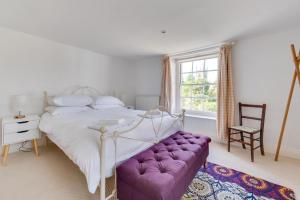 a bedroom with a white bed and a purple couch at 4 Bed in Wangford oc-2tov in Wangford