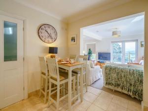 a dining room with a table and a clock on the wall at 3 Bed in Keswick oc-90266 in Applethwaite