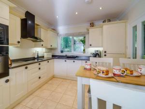 a kitchen with white cabinets and a wooden table at 3 Bed in Keswick oc-90266 in Applethwaite +11 photos