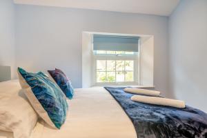 a bedroom with a large bed with pillows and a window at 3 Bed in Minehead oc-r30941 in Minehead