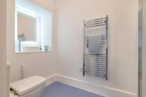 a white bathroom with a toilet and a mirror at 3 Bed in Minehead oc-r30941 in Minehead +24 photos