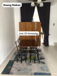 a dining room with a wooden table and chairs at Ismi SA Homestay in Rawang