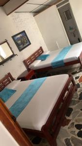 two beds in a room with at Hotel Americano Plus in Pereira +7 photos