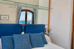 a bedroom with two blue chairs and a window at Villa Azzurra in Cannigione