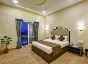 a bedroom with a bed and a window with a view at Breeze Resort Panhala , Swimming Pool, Just 5 Minutes From Panhala! in Panhāla +52 photos