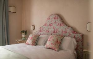 a bed with a floral headboard and two pillows at Dimora Tre Galline in Canale +57 photos