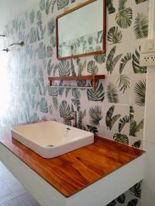 a bathroom with a white sink on a wooden counter at Koh Phaluai beach cottage in Koh Phaluai +85 photos