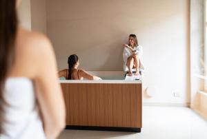 a woman sitting on top of a bath tub in a mirror at Dimora Tre Galline in Canale