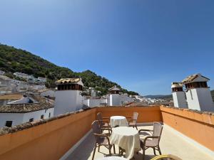 a patio with tables and chairs on a roof at jade in Ubrique