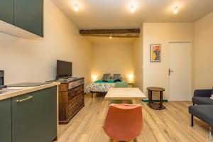 a room with a kitchen and a bedroom with a bed at Le Figuier - Studio de Charme in Lavaur