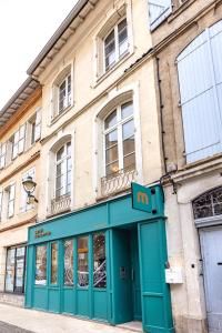 a building with a blue door on a street at Le Figuier - Studio de Charme in Lavaur