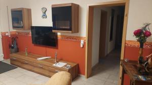 a living room with a television on the wall at Ferienwohnung am Sorpesee in Allendorf