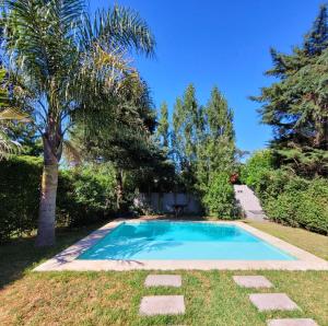 a swimming pool in a yard with trees at Palmeras del sur in Mar del Plata