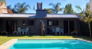 a house with a swimming pool in front of a house at Palmeras del sur in Mar del Plata +3 photos