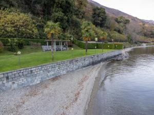 a stone retaining wall next to a river at Apartment Blu Lake by Interhome in Ghiffa