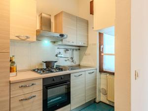 a kitchen with wooden cabinets and a stove top oven at Apartment Casa Silvia by Interhome in Carlazzo