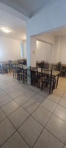 a dining room with wooden chairs and tables in a room at Hotel Necochea in Mendoza
