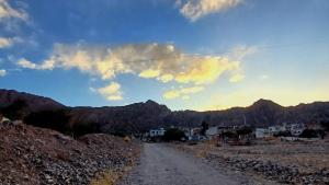 a dirt road with houses and mountains in the background at Cabaña Aklla in Tilcara