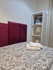 a room with a bed with purple cushions at Studio Apartman 47B in Valjevo