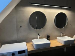 a bathroom with two sinks and two mirrors at JAMY HOUSE Apartmán in Habovka +25 photos