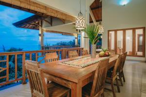 a dining room with a wooden table and chairs at Villa Le Tito in Lovina