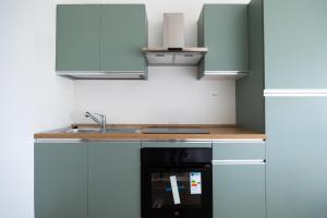 a kitchen with white cabinets and a black oven at I Tigli in Valmontone +22 photos