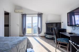 a bedroom with a bed and a desk and a television at I Tigli in Valmontone