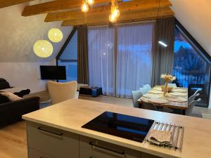 a kitchen and living room with a table and a couch at JAMY HOUSE Apartmán in Habovka