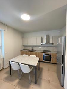 a kitchen with a table and chairs and a refrigerator at Manzoni in Esine