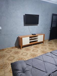 a living room with a flat screen tv on a cabinet at Casa a 4 km do centro e Shopping Campo Grande in Campo Grande