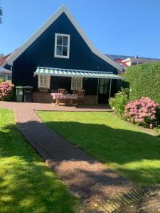 a blue house with a picnic table in a yard at B&B De Singel in Medemblik