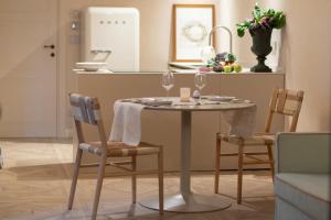 a dining room table with two chairs and a kitchen at Dimora Tre Galline in Canale