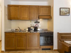 a kitchen with wooden cabinets and a stove at Apartment The Silent Sylva by Interhome in Isolaccia +30 photos