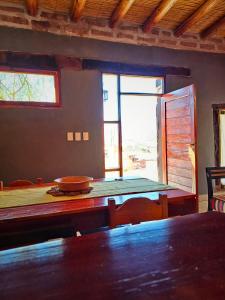 a dining room with a table and chairs and a window at Cabaña Aklla in Tilcara