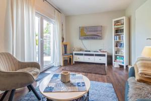 a living room with a couch and a table at Ferienhaus-Mackeriege in Norden