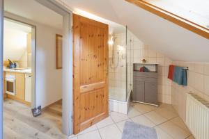 an attic bathroom with a shower and a wooden door at Gästehaus Höfler in Bayerisch Gmain +24 photos