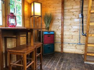 a room with a refrigerator and a table and stool at Funky Bunky in Nelson