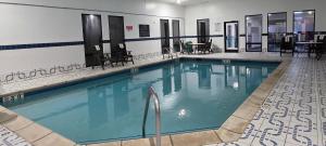 a swimming pool with blue water in a building at Sonesta Essential Ames in Ames