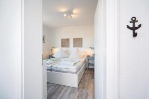 a bedroom with two beds and a cross on the wall at Solymar Whg 64 in Grömitz
